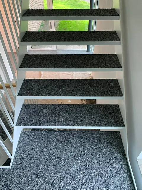 Antracietgrijze traptreden op een open trap met tuinuitzicht