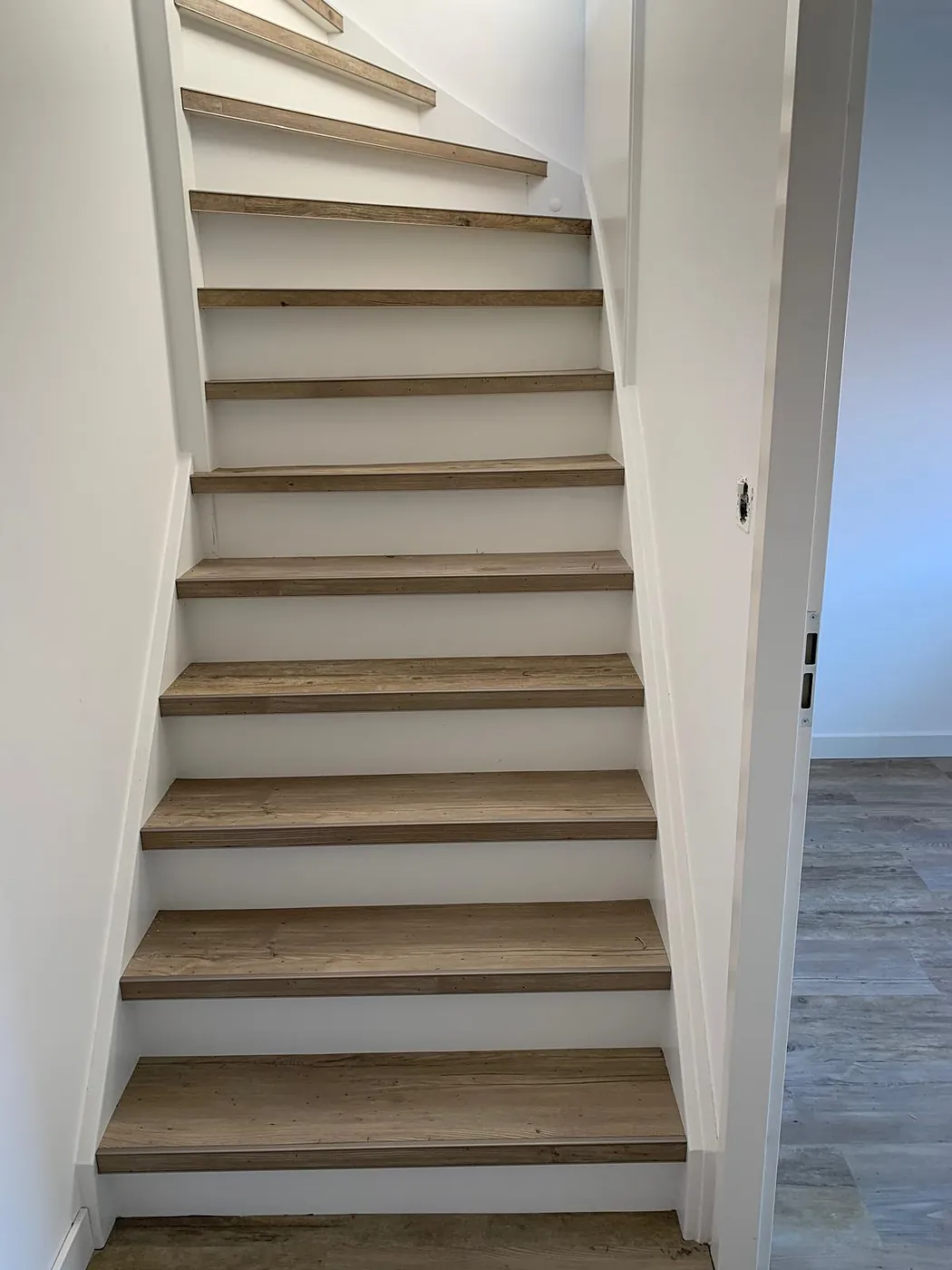 Rechte trap met naturel houten treden en witte stootborden