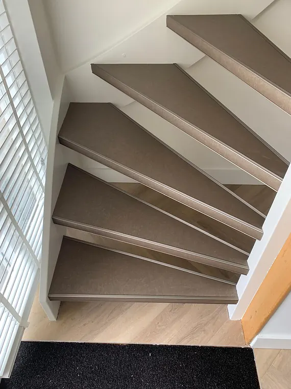 Zwevende trap met taupe tredebekleding en aluminium anti-slipprofielen
