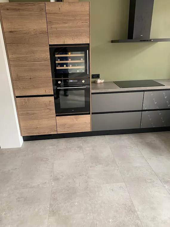 Grijze betonlook tegelvloer in een moderne keuken met hout- en grijstinten