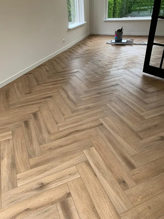Warme eiken visgraatvloer in een lichte woonkamer met veel daglicht